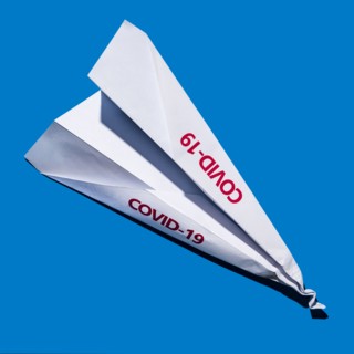 Studio shot of paper plane with Covid-19 sign
