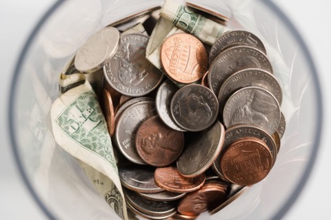 Overhead view of American cents and banknotes in jar