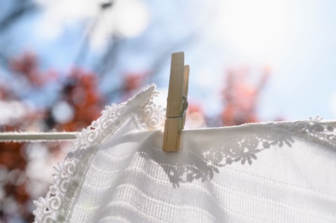 White tablecloth drying on clothesline in sunlight