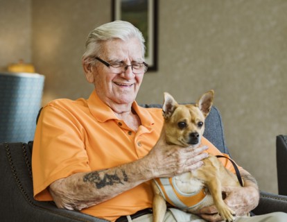 Senior man holding service dog