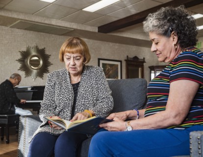 Senior women looking at album