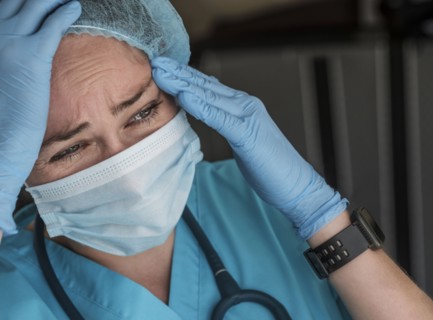 Nurse in face mask experiencing symptoms