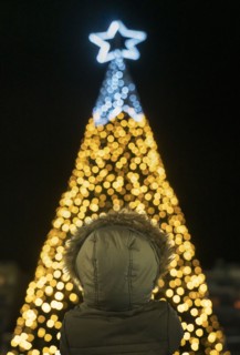 Boy in front of illuminated Christmas tree