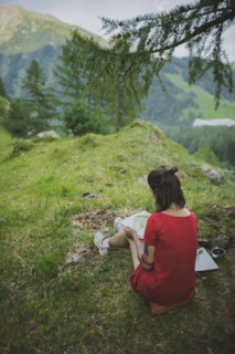 Switzerland, Obergoms, Young woman painting with watercolor in Swiss Alps