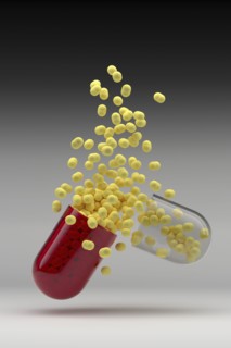 Studio shot of capsule with yellow pills inside