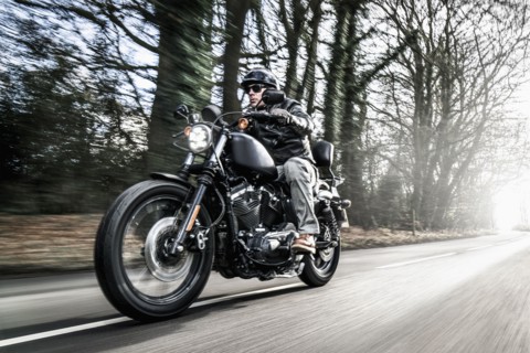 United Kingdom, London, Motorcyclist on road in forest