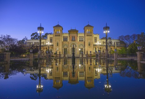 Spain, Seville, Museum of Arts and Popular Customs of Seville reflecting in pond