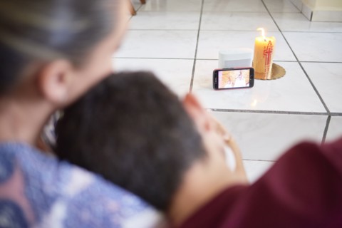Family attending mass on cellphone