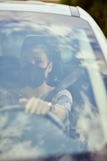 Woman with face mask driving car