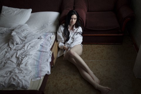 Semi-dress woman sitting on floor in bedroom