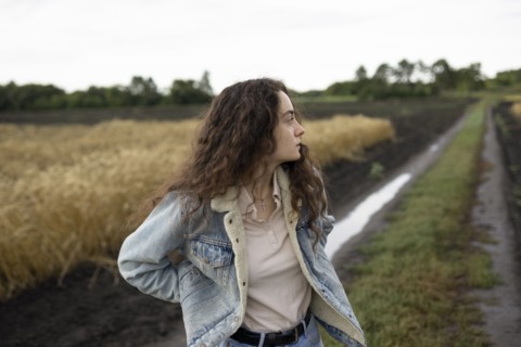 Russia, Omsk, Young woman standing in field