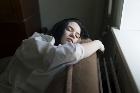 Young woman leaning by window