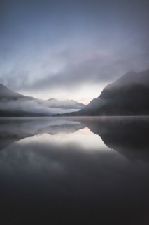 Austria, Plansee, Lake Plansee at sunrise in fog with Austrian Alps