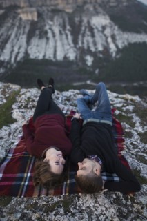 Ukraine, Crimea, Young couple lying down at plaid near canyon
