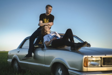 Ukraine, Crimea, Couple sitting on old fashioned car in rural scenery