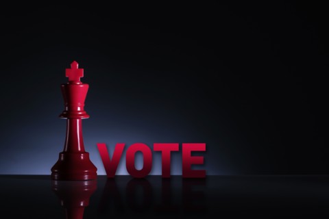 Studio shot of red chess king with word Vote