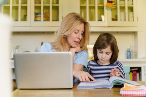 Mother helping daughter (6-7) doing homework