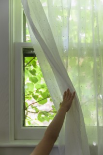 Girl (6-7) opening curtain