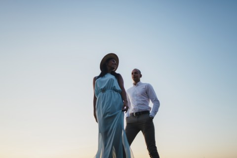 Couple against sunset sky