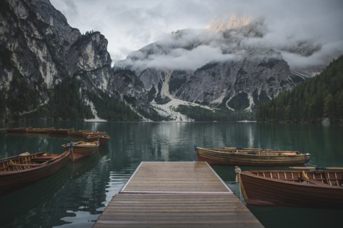 Italy, Wooden boats moored by pier at Pragser Wildsee in Dolomites,