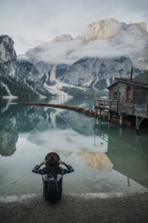 Italy, Woman sitting by Pragser Wildsee in Dolomites,