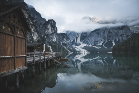 Italy, Wooden houses and pier at Pragser Wildsee in Dolomites,