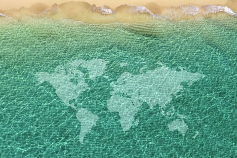 World map against beach wave,,