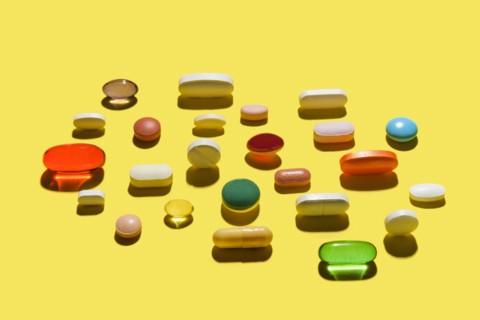 Pills and capsules on yellow