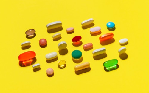 Pills and capsules on yellow