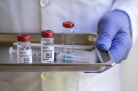 Person wearing glove holding medicine tray