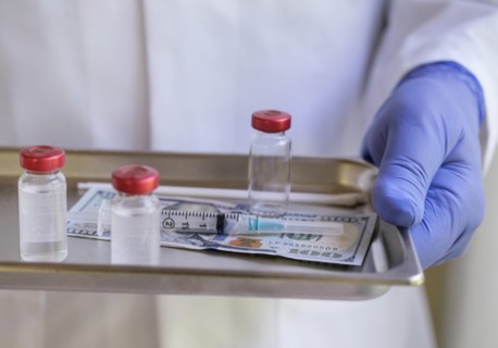 Person wearing glove holding medicine tray