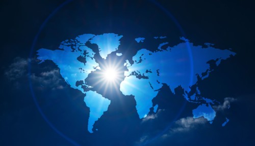 World map against sun and clouds,,