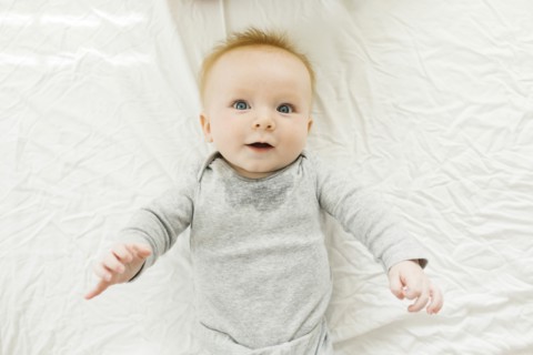 Portrait of baby boy lying on bed