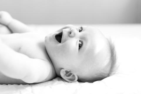 Smiling baby boy lying on bed