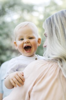 Baby boy laughing in mothers arms