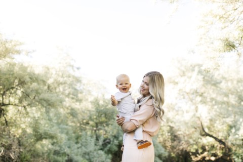 Mother carrying baby boy in nature