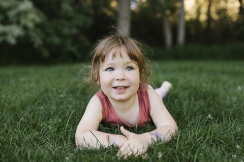 Girl (2-3) lying on grass