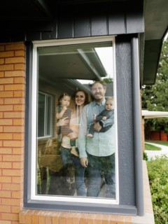 Family with children (6-11 months, 2-3) looking through window,