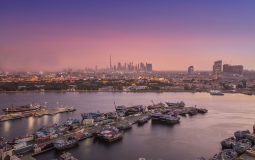 United Arab Emirates, Dubai, Boats on Dubai Creek and skyline at sunset