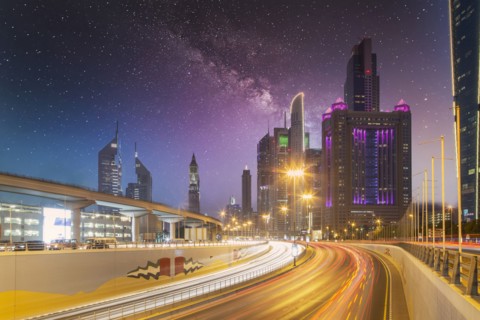 United Arab Emirates, Dubai, Traffic on highway and modern city architecture at dusk