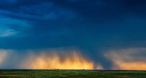 USA, South Dakota, Sun breaking through storm clouds and rain at sunset