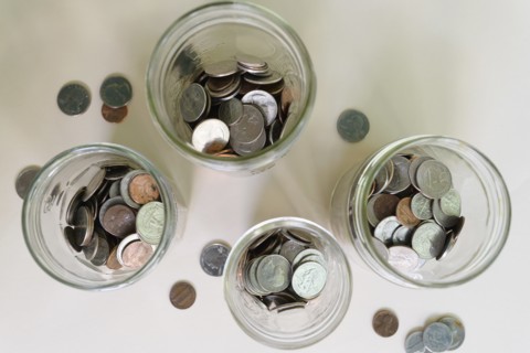 Jars with money on white background