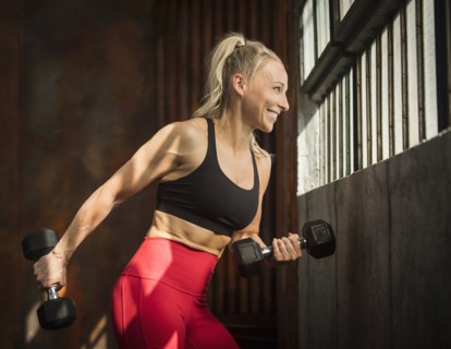 Sporty woman lifting dumbbells