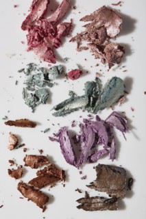 Crushed colorful eye shadows on white background