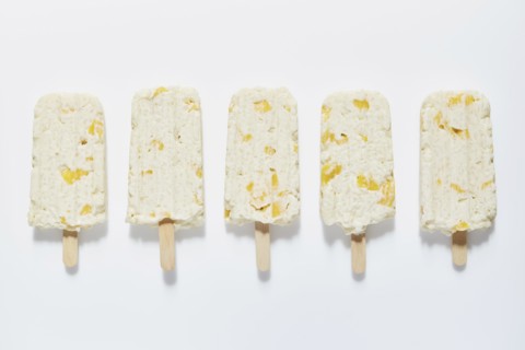 Rice and mango popsicle sticks on white background