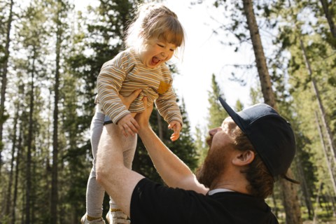 Father holding smiling daughter