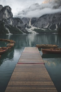 Italy, Pragser Wildsee, Dolomites, South Tyrol, Rowboats moored near jetty in mountain lake