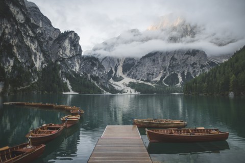 Italy, Pragser Wildsee, Dolomites, South Tyrol, Rowboats moored near jetty in mountain lake