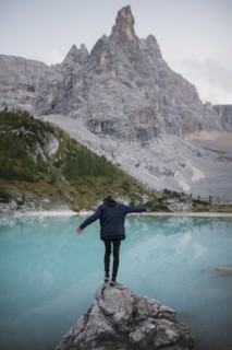 Italy, South Tyrol, Cortina d Ampezzo, lake Sorapis, Man standing on top of rock catching balance