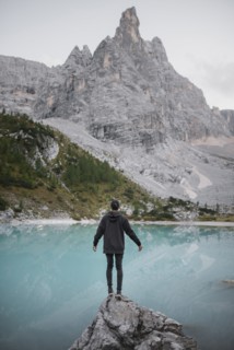Italy, South Tyrol, Cortina d Ampezzo, lake Sorapis, Man standing on rock looking at lake